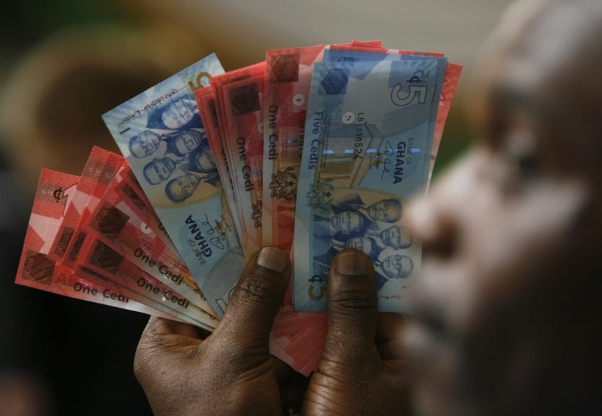A man holds Ghana's cedi notes in Accra
